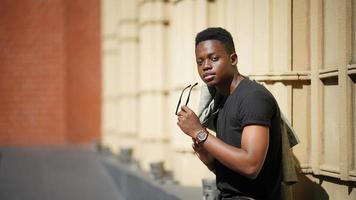 homme afro-américain s'amusant à marcher dans le centre-ville - jeune homme heureux profitant d'un coucher de soleil en plein air - mode de vie de la génération du millénaire et concept d'attitude positive des personnes photo