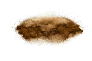 particules brun foncé éclaboussé sur fond blanc. éclaboussure de poussière brune. photo