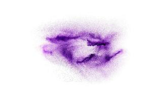explosion abstraite de poudre violette sur fond blanc, mouvement figé d'éclaboussures de poussière violette. photo
