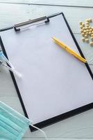 cahier pour notes, médicaments, seringues. tourné sur un fond en bois blanc d'en haut.