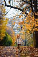 belle fille rousse aux cheveux bouclés et aux yeux bleus. la fille porte une veste à carreaux. la fille est assise sur un banc. photo