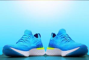 chaussures de sport ou de course bleues pour coureur avec réflexion sur fond flou isolé photo