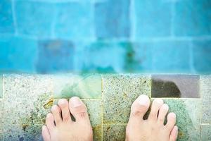 pieds et orteils au bord de la piscine dans le concept de vacances photo