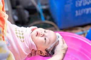 maman asiatique douche bébé pour nettoyer la saleté donner à l'enfant dans le bain récipient pour la propreté mode de vie famille entre mère et enfant utilisé pour la douche de bébé produits crème shampooings lotions et produits de soin pour bébé photo