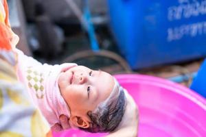 maman asiatique douche bébé pour nettoyer la saleté donner à l'enfant dans le bain récipient pour la propreté mode de vie famille entre mère et enfant utilisé pour la douche de bébé produits crème shampooings lotions et produits de soin pour bébé photo