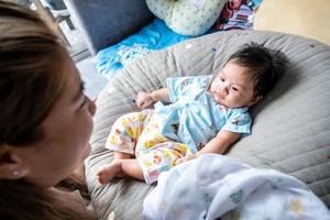 bébé nouveau-né asiatique enfant contact visuel avec maman gentillesse des enfants avec une famille heureuse sur un matelas moelleux métaphore vivre la vie mode de vie sain mignon de produits pour bébé enfant produits de santé pour la mère et le bébé photo