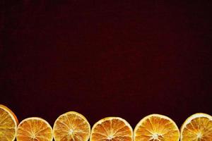 tranches d'orange séchées sur fond de velours rouge photo