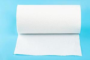 Rouleau de papier essuie-tout blanc sur fond bleu photo
