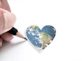 main écrivant un globe en forme de coeur représentant des éléments d'amour de cette image fournie par la nasa. photo