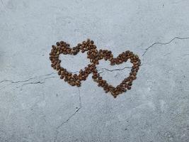 concept d'amour ou de saint valentin. Fermé les grains de café en forme de coeur sur fond de papier peint gris isolé photo