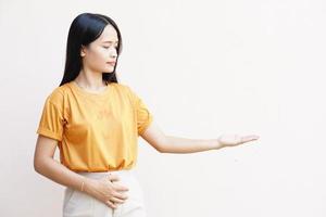 jeune femme sur fond gris isolé tenant un espace de copie fantastique sur la paume pour insérer une annonce. photo