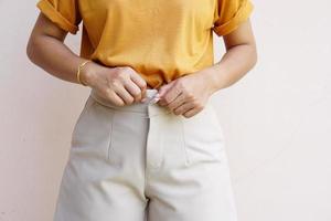 vue partielle d'une femme sexy décompressant un jean isolé sur gris photo