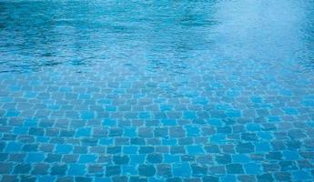 la surface réfléchissante de la piscine. vagues d'eau, la surface de la piscine a un sol carrelé. photo