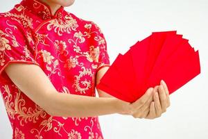 femme asiatique tenant une enveloppe rouge, femme portant du cheongsam, nouvel an chinois photo