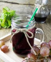 raisins frais et jus sur table en bois photo