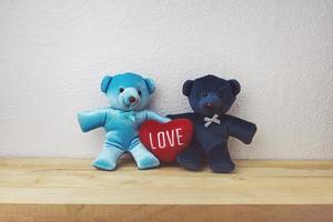 joli ours en peluche et forme de coeur rouge assis sur une table en bois photo