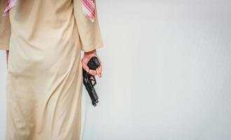 homme arabe debout avec la main tenant le pistolet photo