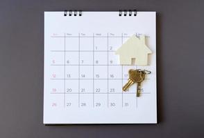 calendrier et maison sur table. jour de l'achat ou de la vente d'une maison ou du paiement d'un loyer ou d'un prêt. photo