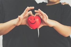 garçon et fille tiennent un coeur rouge photo