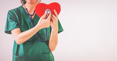 médecin avec stéthoscope examinant le coeur rouge photo