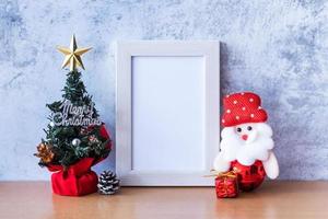 cadre photo et décoration de noël - père noël et cadeau sur table en bois. concept de noël et bonne année