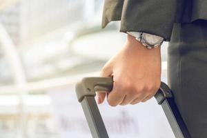 femme d'affaires tirant une valise dans une grande ville. photo