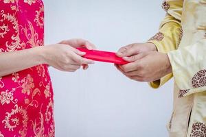 couple asiatique tenant des enveloppes rouges du nouvel an chinois. nouvel An chinois. photo