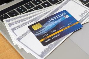 carte de crédit et argent sur un clavier d'ordinateur. concept d'achat en ligne, paiement en ligne photo