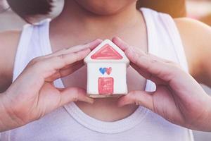 petites mains d'enfant tenant la maison photo