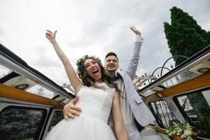 les mariés hipster se tiennent près de leur bus rétro. photo