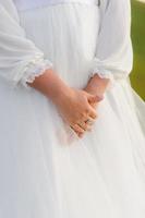 couturière boutonnant la jolie robe de mariée, élégante et dos nu. photo