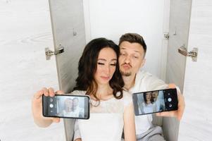 la mariée et le marié prennent un selfie dans le placard. photo