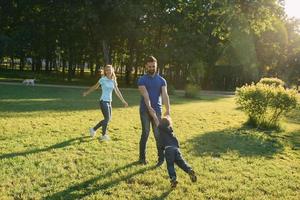 les parents jouent dans le parc avec leur fils photo