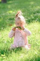 petite fille en vêtements décontractés fait ses premiers pas sur l'herbe. photo