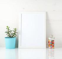 cadre blanc, succulent, bonbons sur tableau blanc contre le mur blanc. maquette avec espace de copie dans un style scandinave photo