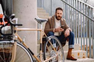 jeune homme à l'aide de smartphone avec application mobile. regarder la caméra photo