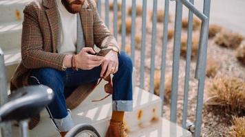 détail de la section médiane de la main avec smartphone. homme d'affaires sans visage à l'aide d'une application de téléphonie mobile. photo