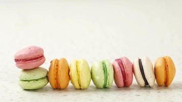 mini macaron de différentes couleurs sur fond crème, photo