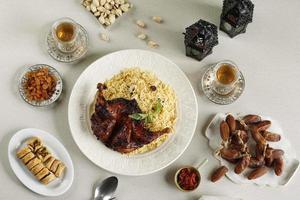 menu iftar du ramadan, kabsa de riz basmati avec poulet rôti, raisins secs, thé, dattes, pistache et baklava turc photo