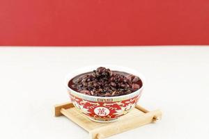 soupe de haricots rouges et bouillie de riz violet avec pot de lait sur le dessus de la table en bois photo