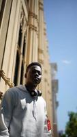 homme afro-américain s'amusant à marcher dans le centre-ville - jeune homme heureux profitant d'un coucher de soleil en plein air - mode de vie de la génération du millénaire et concept d'attitude positive des personnes photo