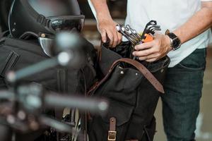 le cavalier prépare les outils et les met dans la sacoche ou le sac latéral. concept de voyage moto. mise au point sélective