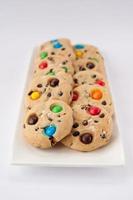 Cookies aux bonbons multicolores sur une plaque rectangulaire blanche