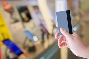 main tenant une carte de crédit dans un magasin de téléphonie mobile photo