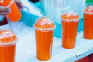 smoothie orange dans une tasse en plastique photo