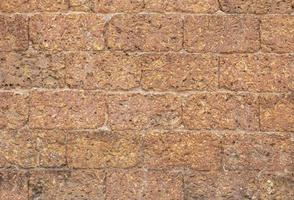 flou de mur de briques de latérite rouge motif de fond poreux et à grain fin photo