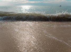 éclaboussure de vague de mer sur le sable photo