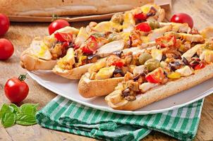 gros sandwich aux légumes rôtis et poulet au fromage et basilic sur fond de bois ancien photo