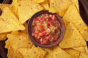 Croustilles de nacho mexicaines et trempette de salsa dans un bol sur fond de bois photo