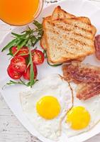 petit-déjeuner anglais - pain grillé, œuf, bacon et légumes photo